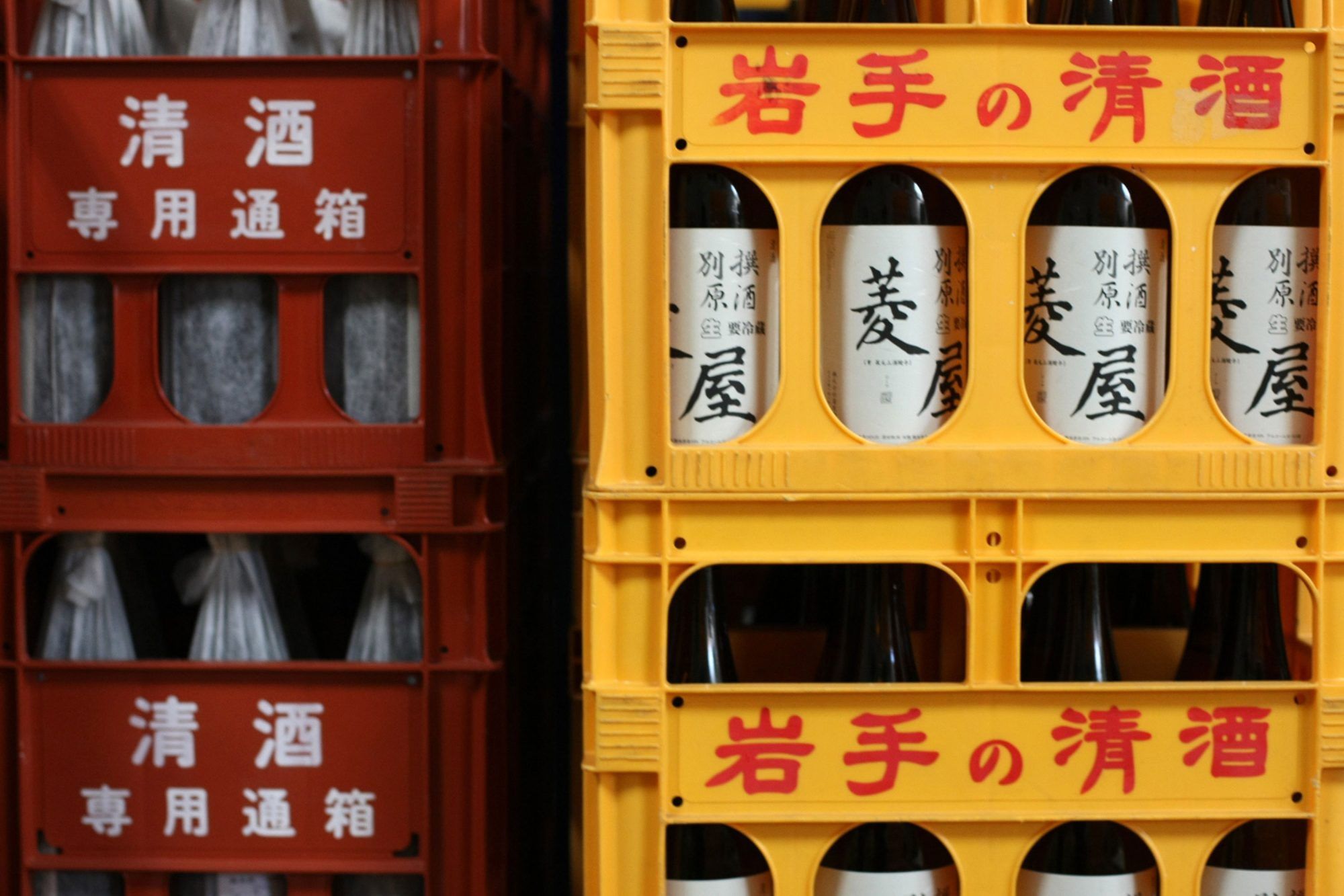 Crates containing bottles of sake sit stacked at the Hishiya Japanese Sake Brewery