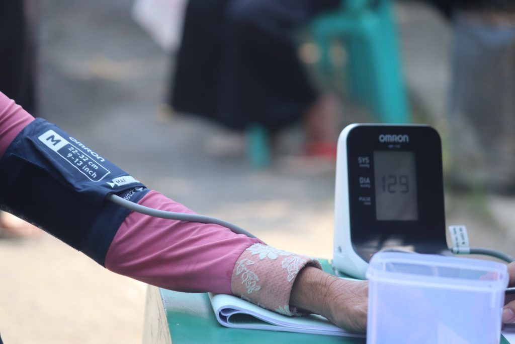 A hand holds the blood pressure machine to check for hypertension
